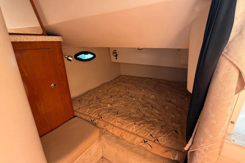 Slide: The Image of 2007 Regal Commodore 2665 cabin interior with cozy bed and wooden cabinet. - 24