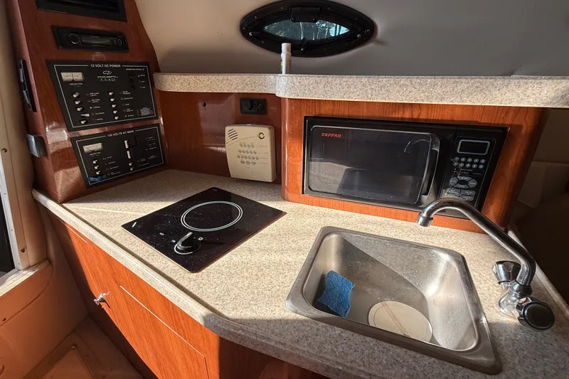 Slide: The Image of 2007 Regal Commodore 2665 boat kitchen with microwave, sink, and control panel. - 22