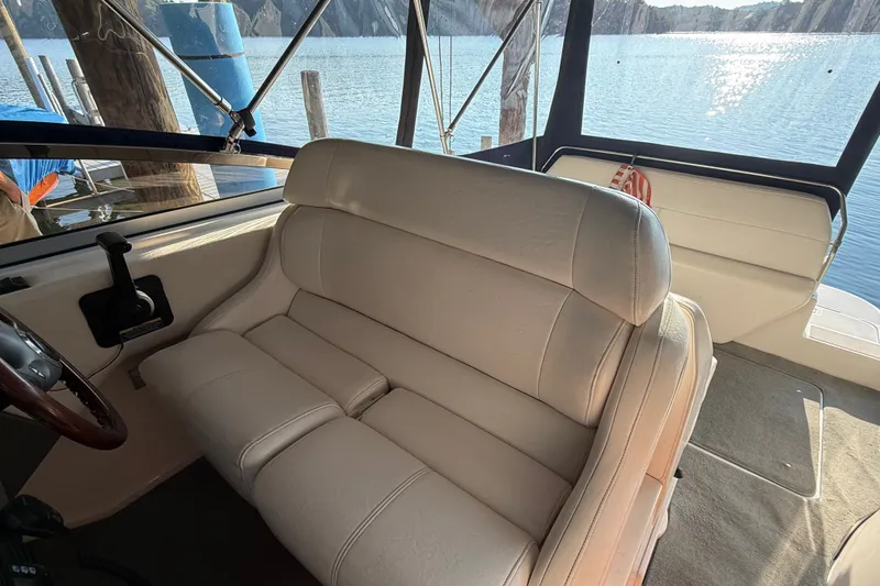 Slide: The Image of Interior of 2007 Regal Commodore 2665 boat with beige seating and scenic water view. - 14