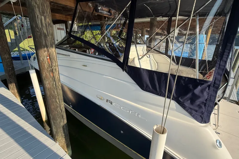 Slide: The Image of 2007 Regal Commodore 2665 boat docked under a wooden shelter. - 4