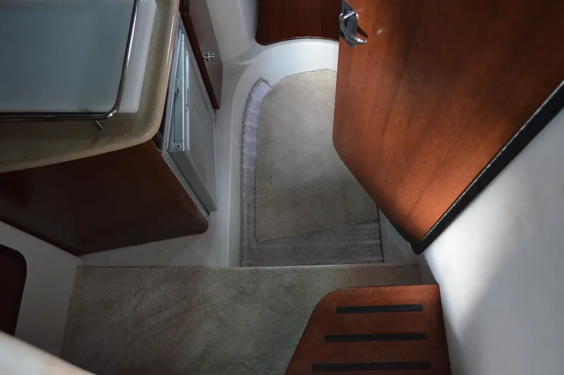Slide: The Image of Interior view of 2024 Crownline 270 CR boat with wood accents and carpeted flooring. - 19