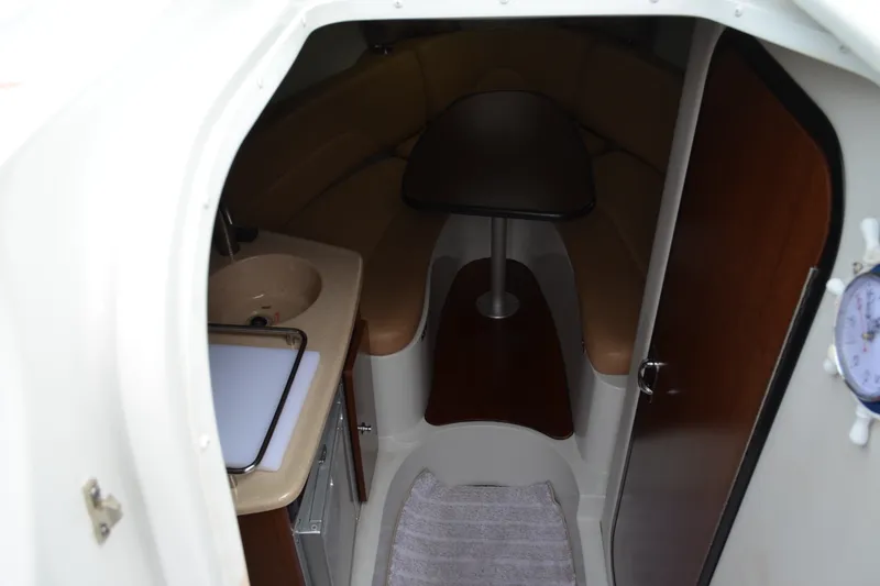 Slide: The Image of 2024 Crownline 270 CR cabin interior with seating, table, and sink. - 20