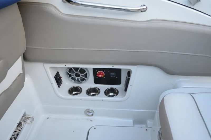 Slide: The Image of 2024 Crownline 270 CR boat interior with speaker, controls, and cup holders. - 7