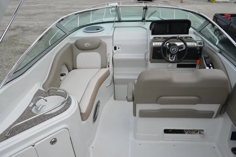 Slide: The Image of 2024 Crownline 270 CR boat interior with helm, seating, and sink area. - 7