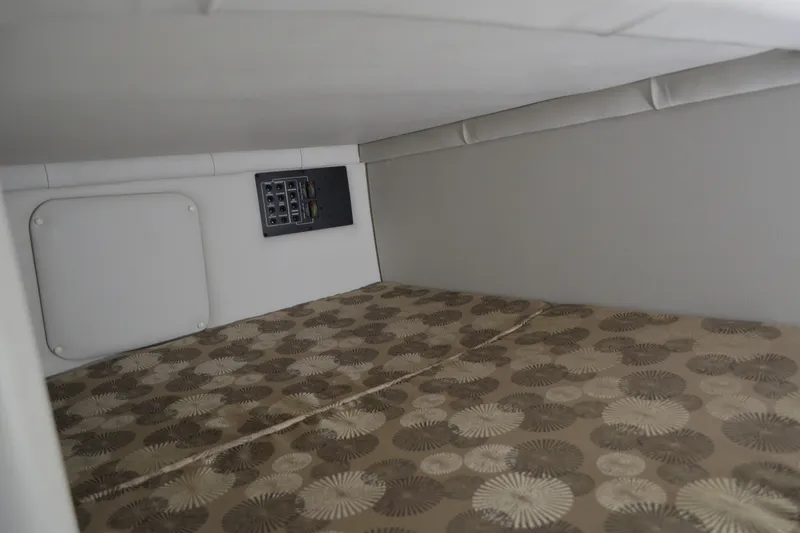 Slide: The Image of 2024 Crownline 270 CR cabin interior with patterned bedding and control panel. - 26