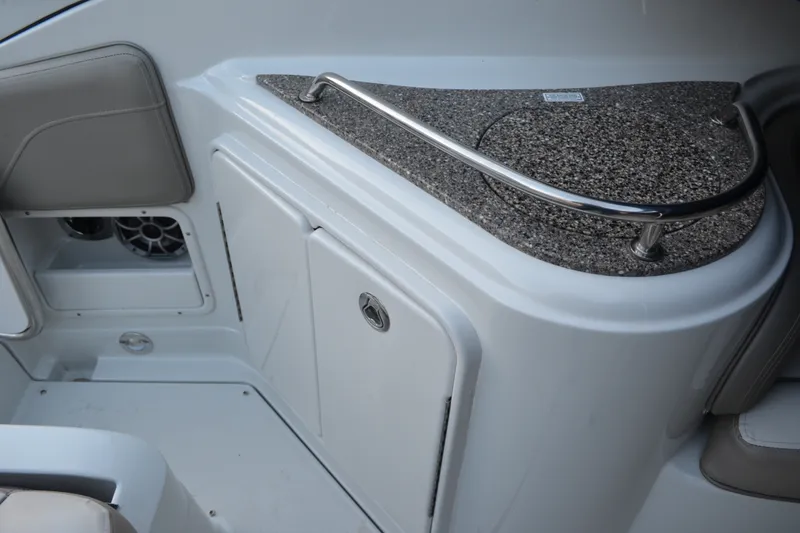 Slide: The Image of 2024 Crownline 270 CR boat interior with granite countertop and storage compartment. - 10