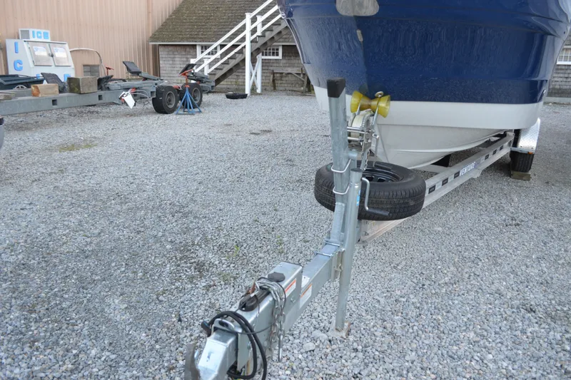 Slide: The Image of 2024 Crownline 270 CR boat on trailer in gravel lot, front view. - 4