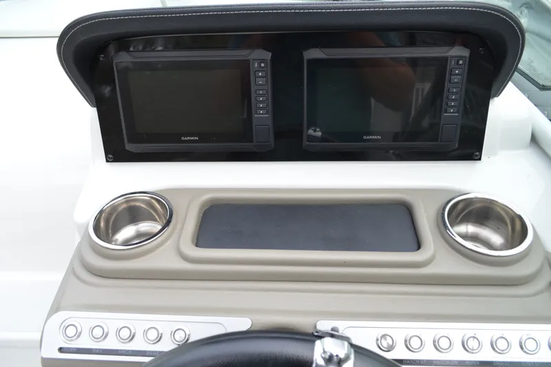 Slide: The Image of 2024 Crownline 270 CR dashboard with dual Garmin displays and cup holders. - 18
