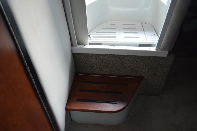 Slide: The Image of 2024 Crownline 270 CR interior step detail with wood finish and carpeted flooring. - 29