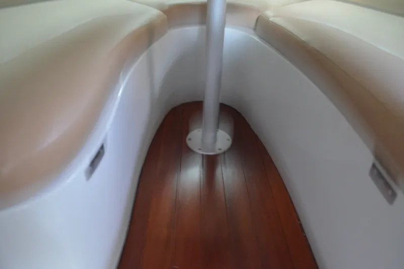 Slide: The Image of 2024 Crownline 270 CR cabin interior with wood flooring and cushioned seating. - 25