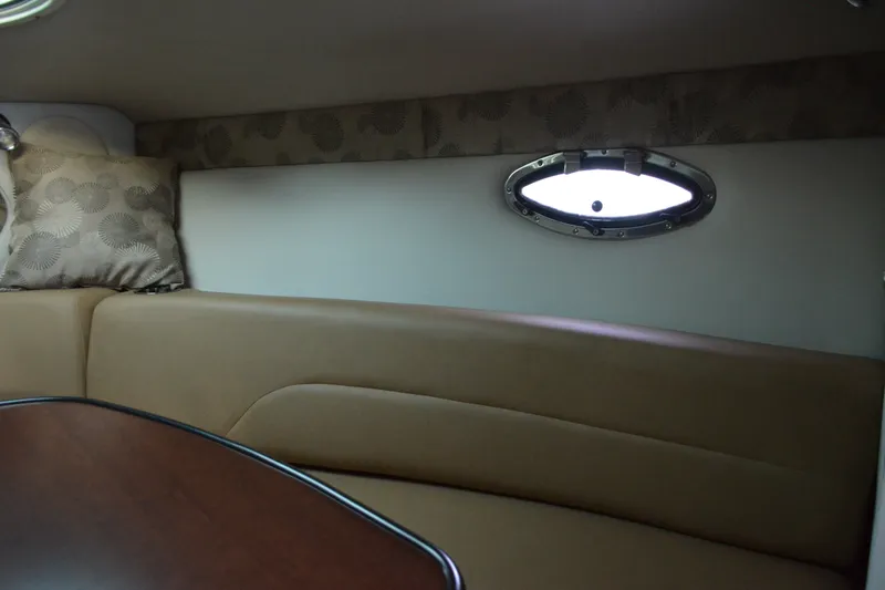 Slide: The Image of 2024 Crownline 270 CR cabin interior with porthole and cushioned seating. - 21
