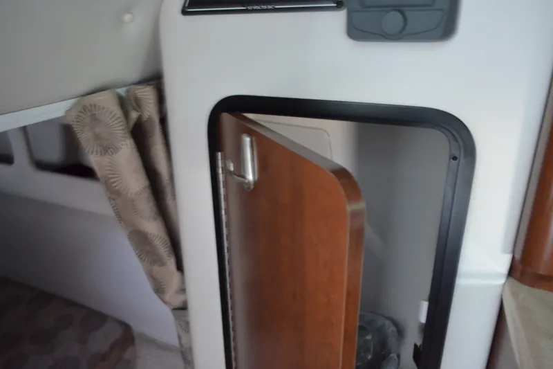Slide: The Image of 2024 Crownline 270 CR cabin interior with open wooden door and patterned curtain. - 24
