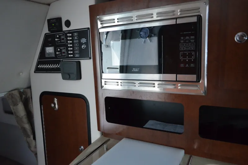 Slide: The Image of 2024 Crownline 270 CR cabin interior with microwave and control panel. - 23