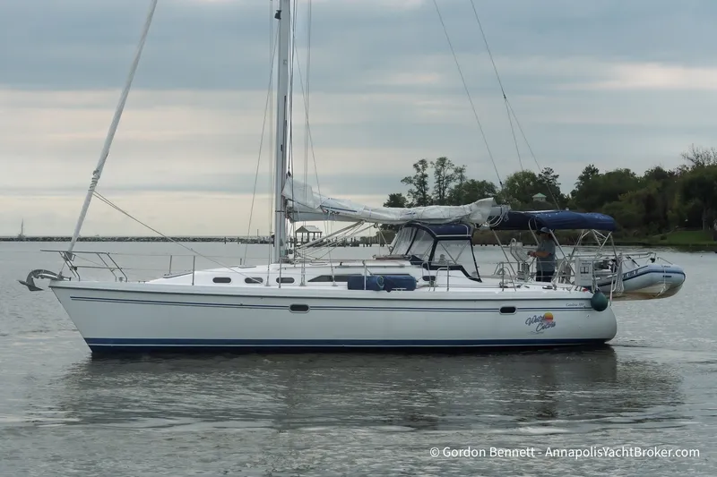 Slide: The Image of Sailboat Catalina 380, 2003 model, anchored on calm water under cloudy skies. - 6