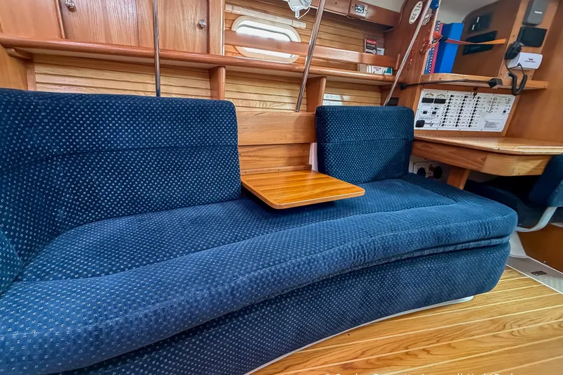 Slide: The Image of Interior of a 2003 Catalina 380 yacht with blue upholstered seating and wooden accents. - 41