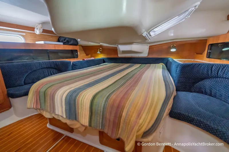Slide: The Image of Cozy cabin interior of a 2003 Catalina 380 yacht with striped bedding and wood accents. - 4