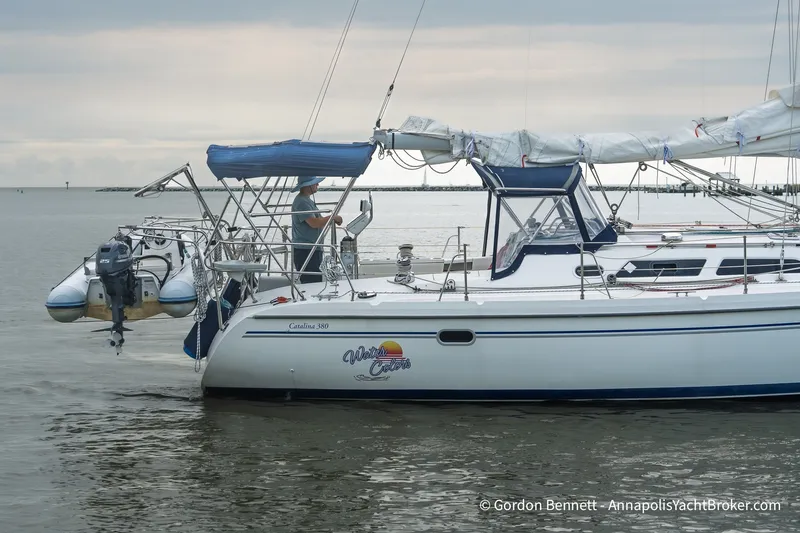 Slide: The Image of Sailboat Catalina 380, 2003 model, anchored on calm waters with a dinghy attached. - 9