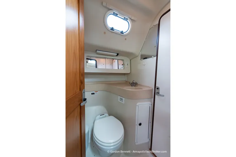 Slide: The Image of Bathroom interior of 2003 Catalina 380 yacht, featuring toilet, sink, and mirror. - 50