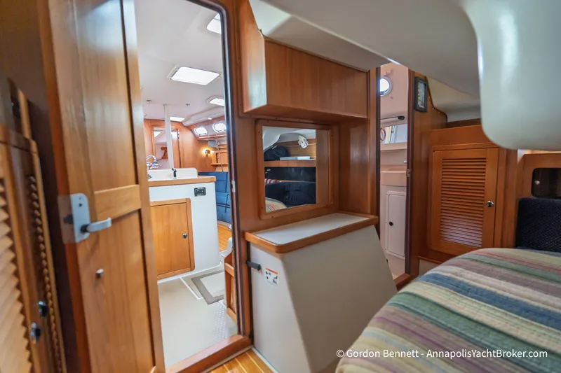 Slide: The Image of Interior of a 2003 Catalina 380 yacht, featuring wooden cabinetry and cozy seating. - 49