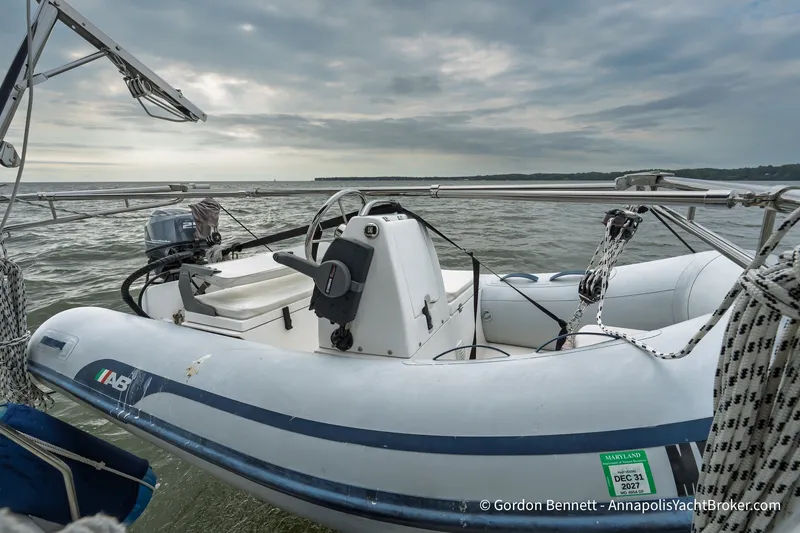 Slide: The Image of A 2003 Catalina 380 sailboat with an inflatable dinghy on calm waters under a cloudy sky. - 26