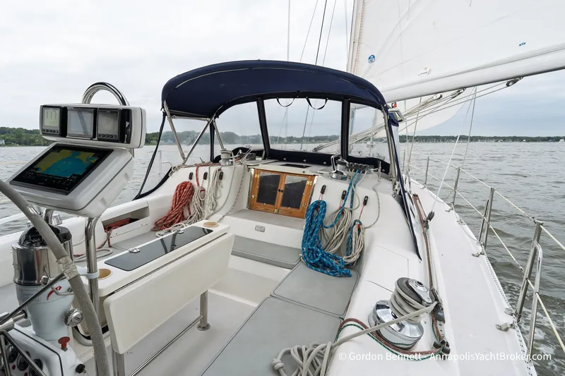 Slide: The Image of Cockpit of a 2003 Catalina 380 sailboat with navigation equipment and ropes on a calm sea. - 23