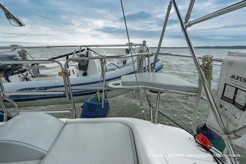 Slide: The Image of 2003 Catalina 380 sailboat deck with dinghy on calm waters. - 25