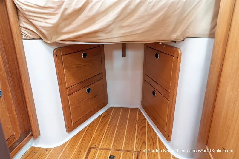 Slide: The Image of Interior of 2003 Catalina 380 yacht showing wooden storage drawers under a bed. - 44