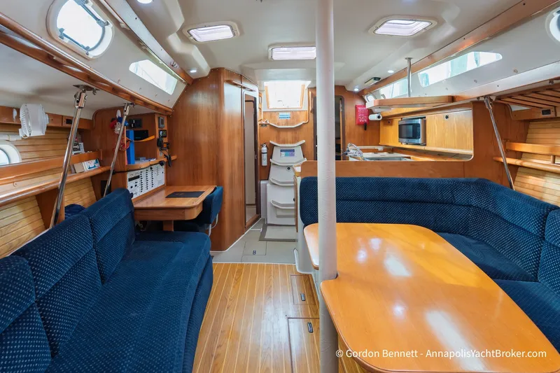 Slide: The Image of Interior of a 2003 Catalina 380 yacht with wooden finishes and blue seating. - 39