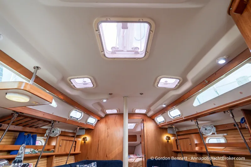 Slide: The Image of Interior of 2003 Catalina 380 yacht, featuring wooden finishes and multiple skylights. - 42