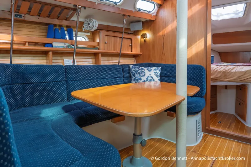 Slide: The Image of Interior of 2003 Catalina 380 yacht with blue seating and wooden table. - 35