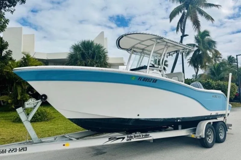 Slide: The Image of 2020 Sea Fox 228 Commander boat on trailer, parked near palm trees. - 0