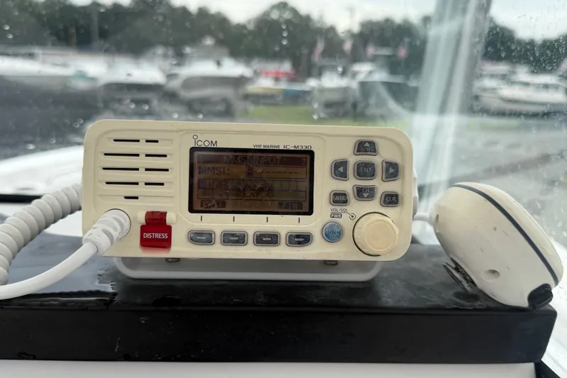 Slide: The Image of VHF marine radio on 2020 Sea Fox 228 Commander boat dashboard, with distress button visible. - 26