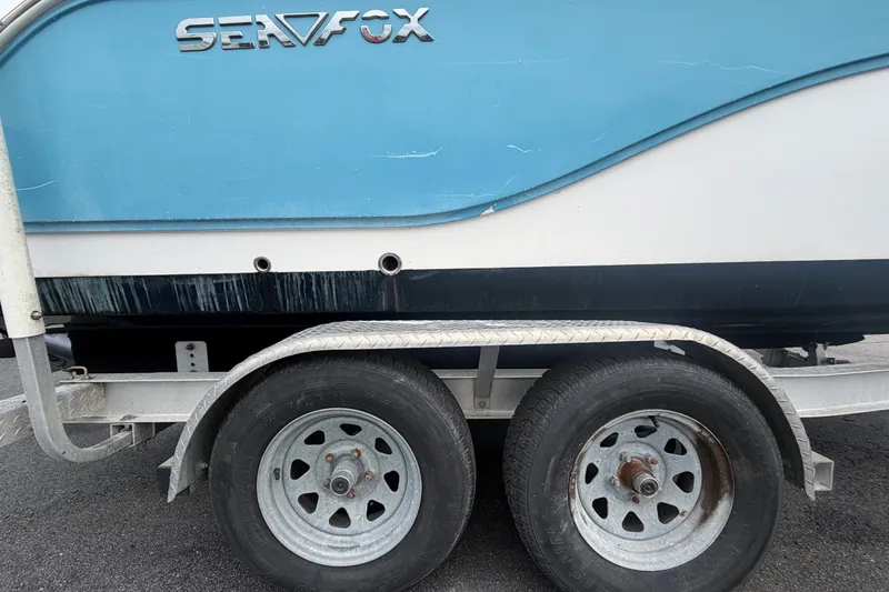 Slide: The Image of 2020 Sea Fox 228 Commander boat on trailer, side view with visible wheels. - 79