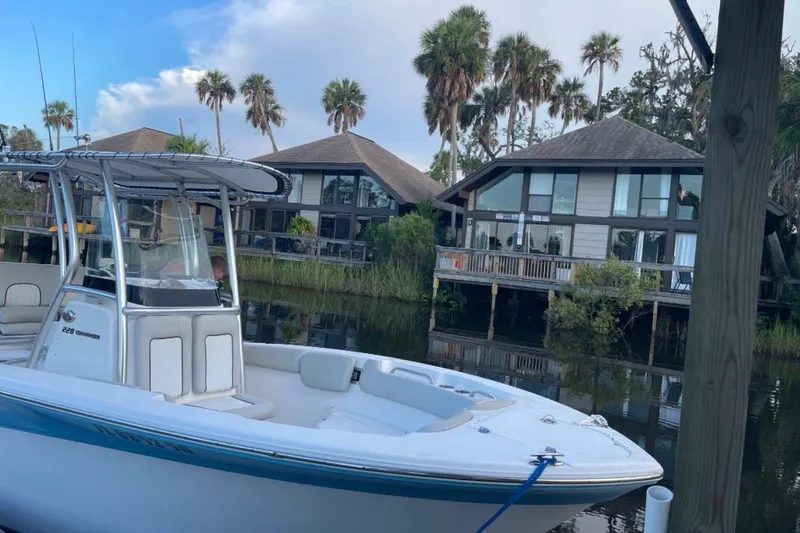 Slide: The Image of 2020 Sea Fox 228 Commander boat docked near waterfront homes with palm trees. - 3