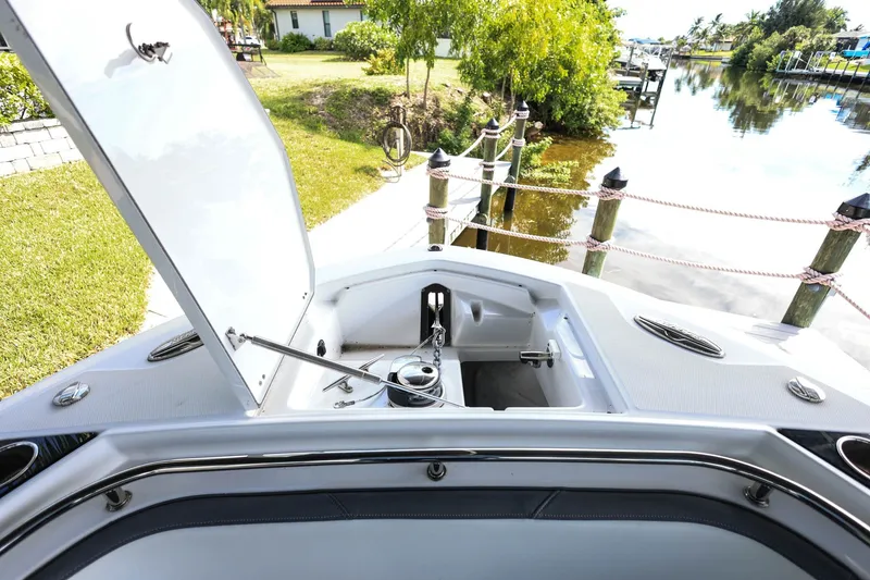 Slide: The Image of Open anchor compartment on 2019 Blackfin 272 CC boat docked by a serene canal. - 17