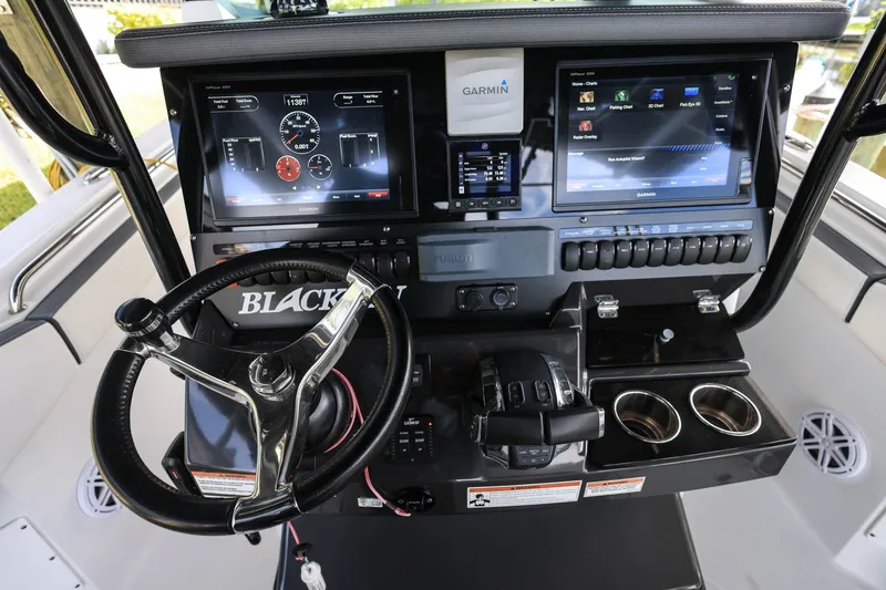 Slide: The Image of 2019 Blackfin 272 CC boat dashboard with Garmin displays and steering wheel. - 11