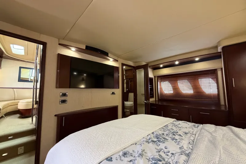 Slide: The Image of Luxurious 2006 Sea Ray 60 Sundancer yacht bedroom with TV and elegant wood finishes. - 28