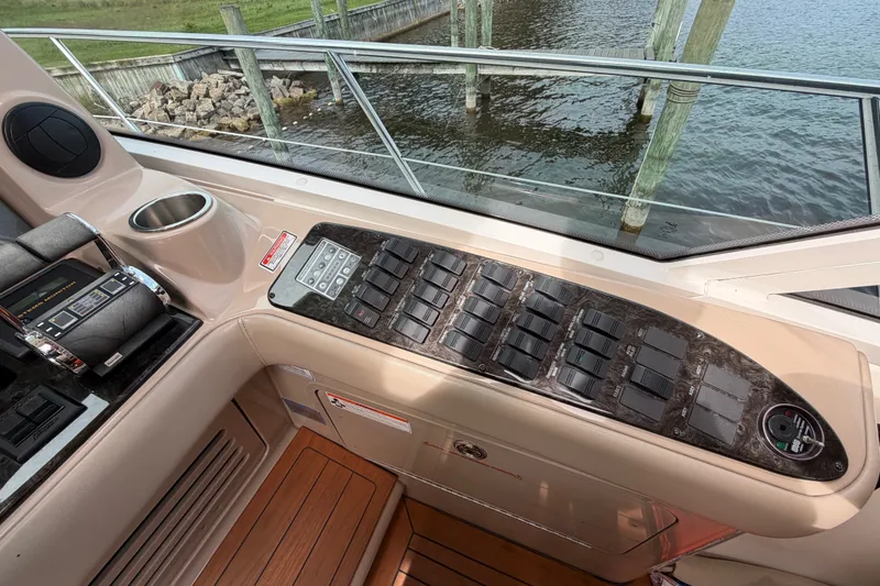Slide: The Image of Control panel of a 2006 Sea Ray 60 Sundancer yacht, featuring switches and throttle controls. - 42