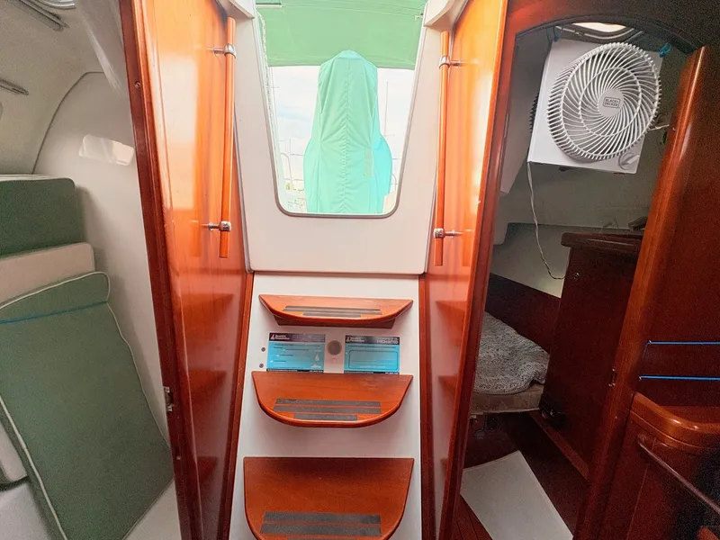 Slide: The Image of The cabin of a 2005 Beneteau Oceanis Clipper 343 with wooden steps and a fan. - 41