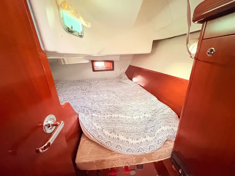 Slide: The Image of The cabin of a 2005 Beneteau Oceanis Clipper 343 with a cozy bed and wood paneling. - 31