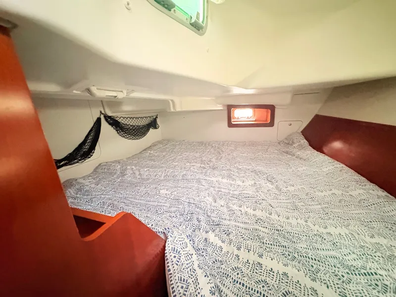 Slide: The Image of The cabin of the 2005 Beneteau Oceanis Clipper 343 features a cozy bed with netted storage. - 33