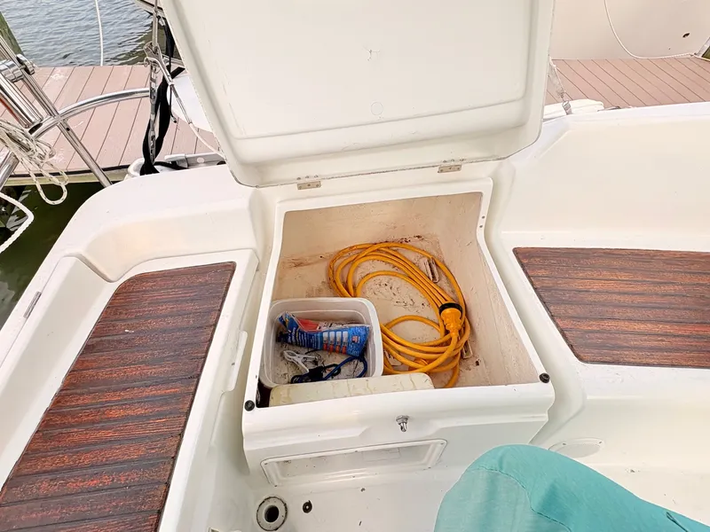 Slide: The Image of An open storage compartment on a sailboat reveals an extension cord and other items. - 18
