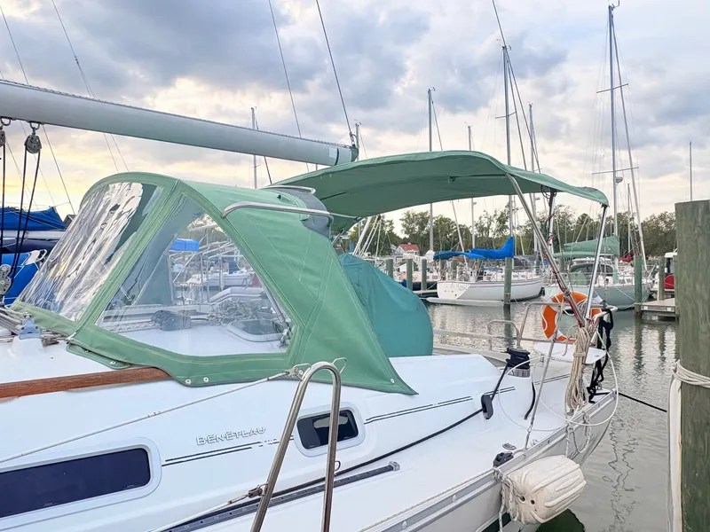 Slide: The Image of A 2005 Beneteau Oceanis Clipper 343 docked at a marina, featuring a green canopy. - 2