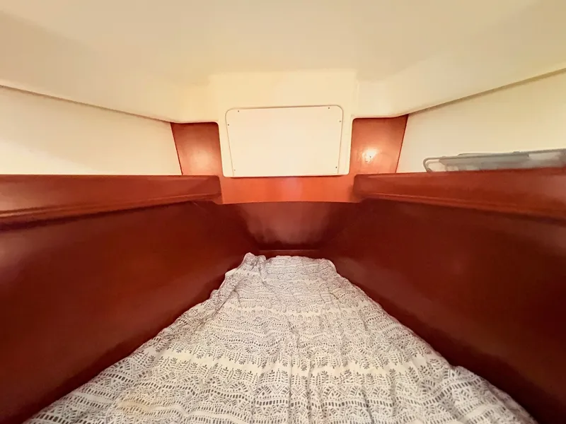 Slide: The Image of Interior view of a cabin with wooden walls and a bed with a patterned bedspread. - 38