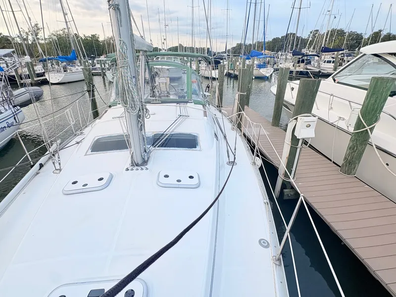 Slide: The Image of The image shows the deck of a 2005 Beneteau Oceanis Clipper 343 docked at a marina. - 13