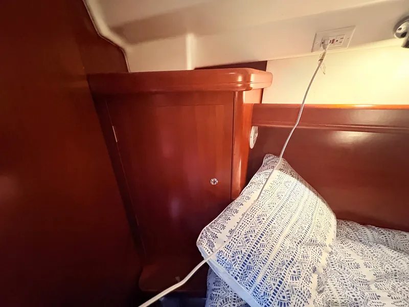 Slide: The Image of The cabin of a 2005 Beneteau Oceanis Clipper 343 with wooden furniture and a patterned pillow. - 39