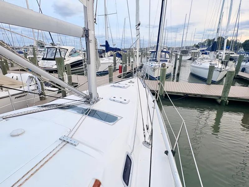 Slide: The Image of The deck of a 2005 Beneteau Oceanis Clipper 343 in a marina, surrounded by other sailboats. - 9