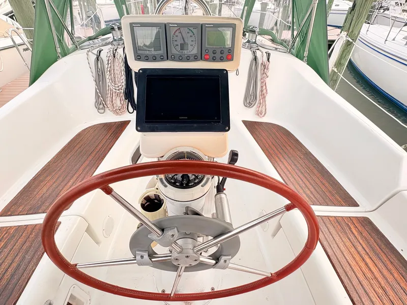 Slide: The Image of The cockpit of the 2005 Beneteau Oceanis Clipper 343 features a steering wheel and navigation instruments. - 7