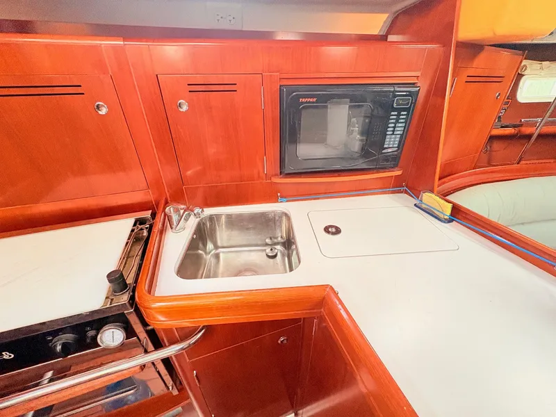 Slide: The Image of The 2005 Beneteau Oceanis Clipper 343 galley features a sink, stove, and microwave. - 28