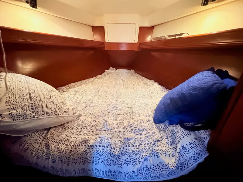 Slide: The Image of The cabin of a 2005 Beneteau Oceanis Clipper 343 with a cozy bed and pillows. - 35